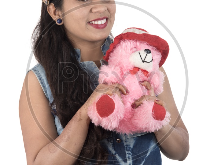 A Pretty Young Beautiful Woman Holding And Playing with Teddy Bear Toy and Posing On an Isolated White Background