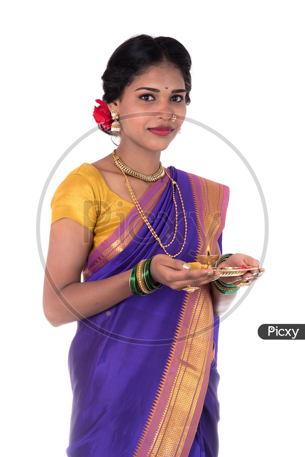 Portrait Of a Beautiful Young Girl Wearing Traditional Saree and holding Pooja Thali Or Plate For  Performing Worship on an Isolated White Background