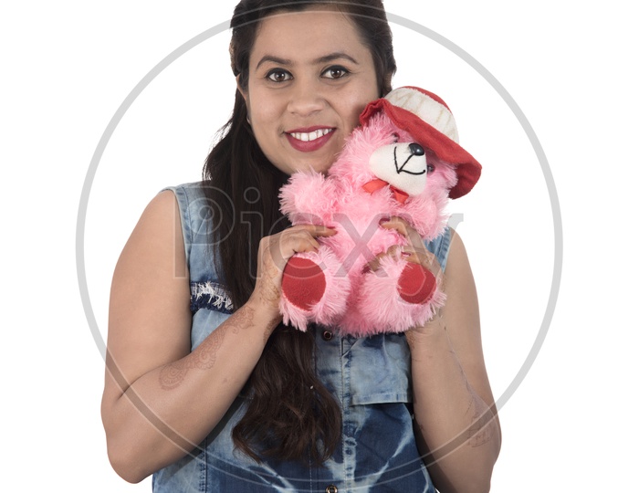 A Pretty Young Beautiful Woman Holding And Playing with Teddy Bear Toy and Posing On an Isolated White Background