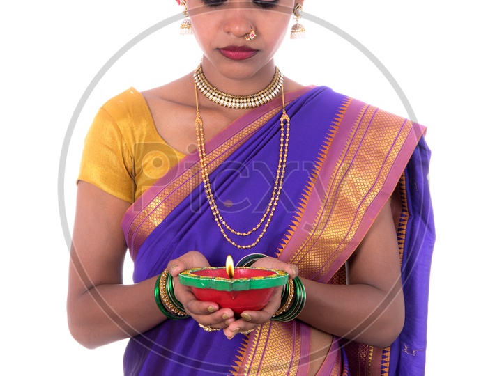 Portrait of a woman holding diya, Diwali or deepavali photo with female hands holding oil lamp during festival of light on white background