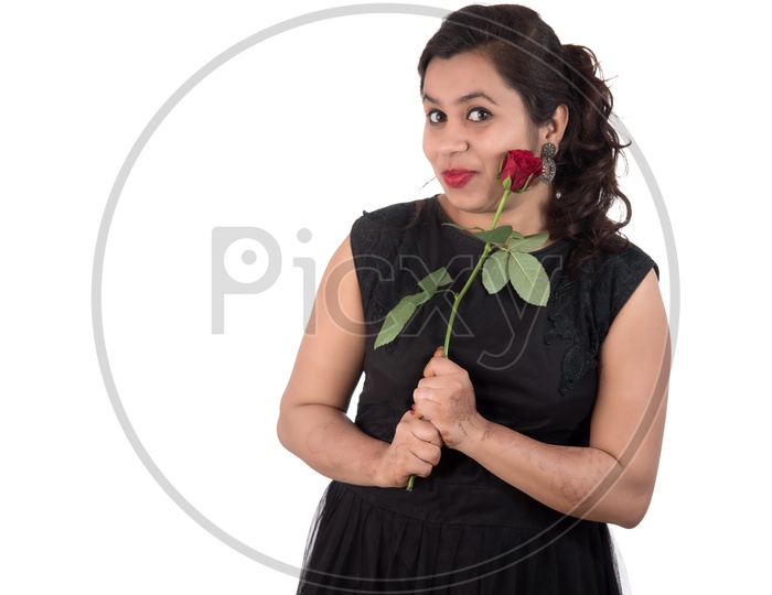 A Pretty Young Beautiful Woman Holding  Red Rose  In Hand And Smiling On an Isolated White Background