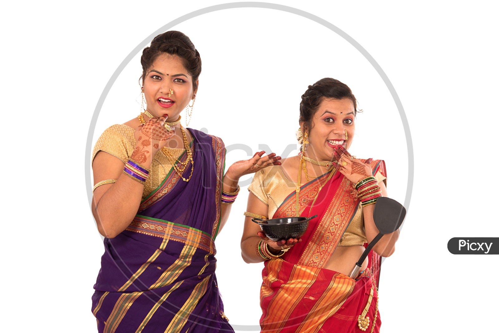 Image of Young Indian traditional Marathi Woman Or Sisters Holding Cooking  Utensils And Posing On an Isolated White Background-BO788518-Picxy