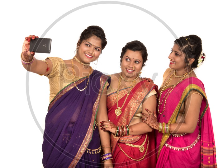 Indian Traditional Marathi Woman or Sisters  Taking Selfies  In Smart Phone On an Isolated White Background