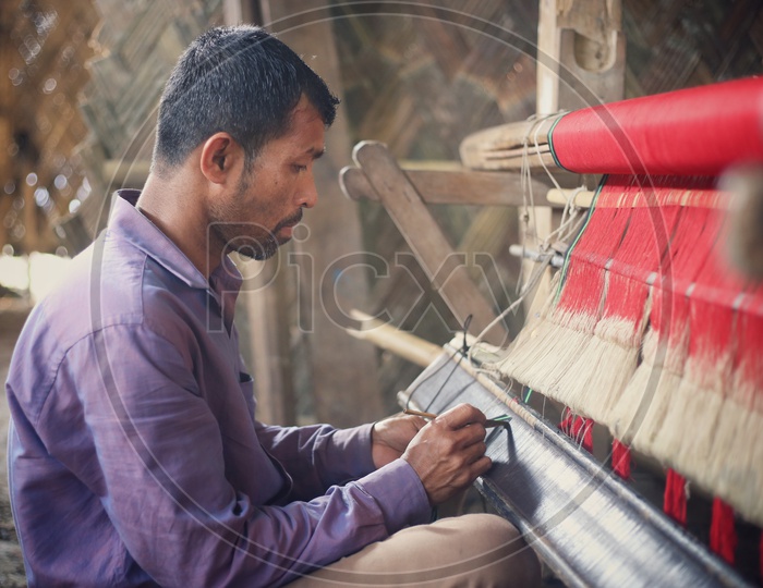 Indian Weavers Weaving The Hand Loom Sarees Or Saris  in a Traditional Weaving Machine In Rural Village House