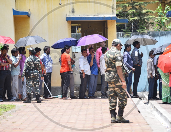 Voters Standing In Queue Lines in Bright Sun Holding  Umbrellas To Cast Their Votes  In Lok Sabha General Elections 2019