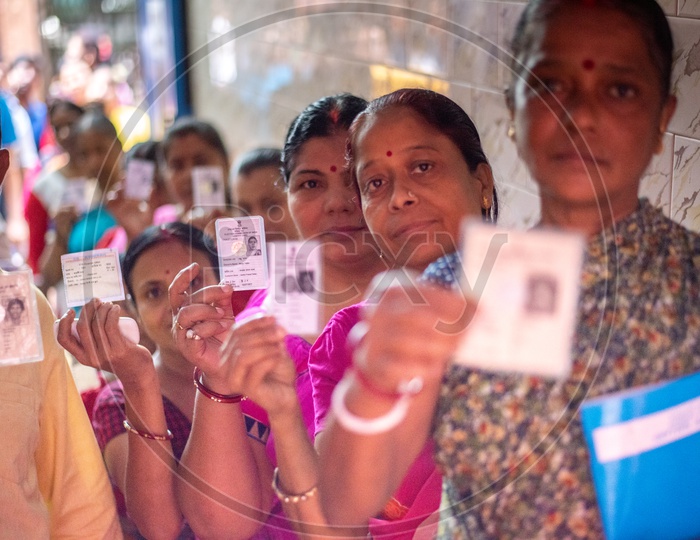 Woman Voters Showing Their Voter Cards Being In Queue Lines At Polling Booths On Election Day
