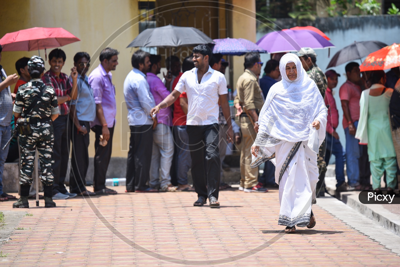 A Woman Covered His Head With Her Veil  Due To Bright Sun at a Polling Station  in West Bengal