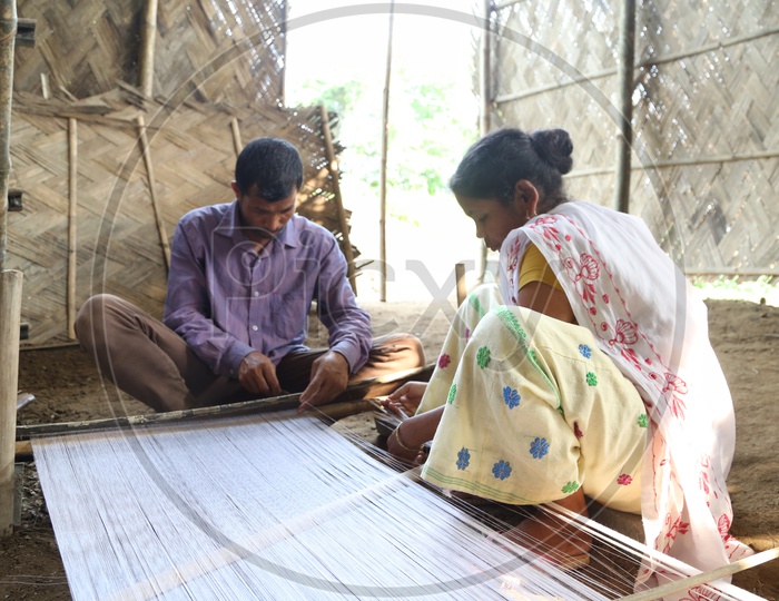 Indian Weavers Weaving The Hand Loom Sarees Or Saris  in a Traditional Weaving Machine In Rural Village House