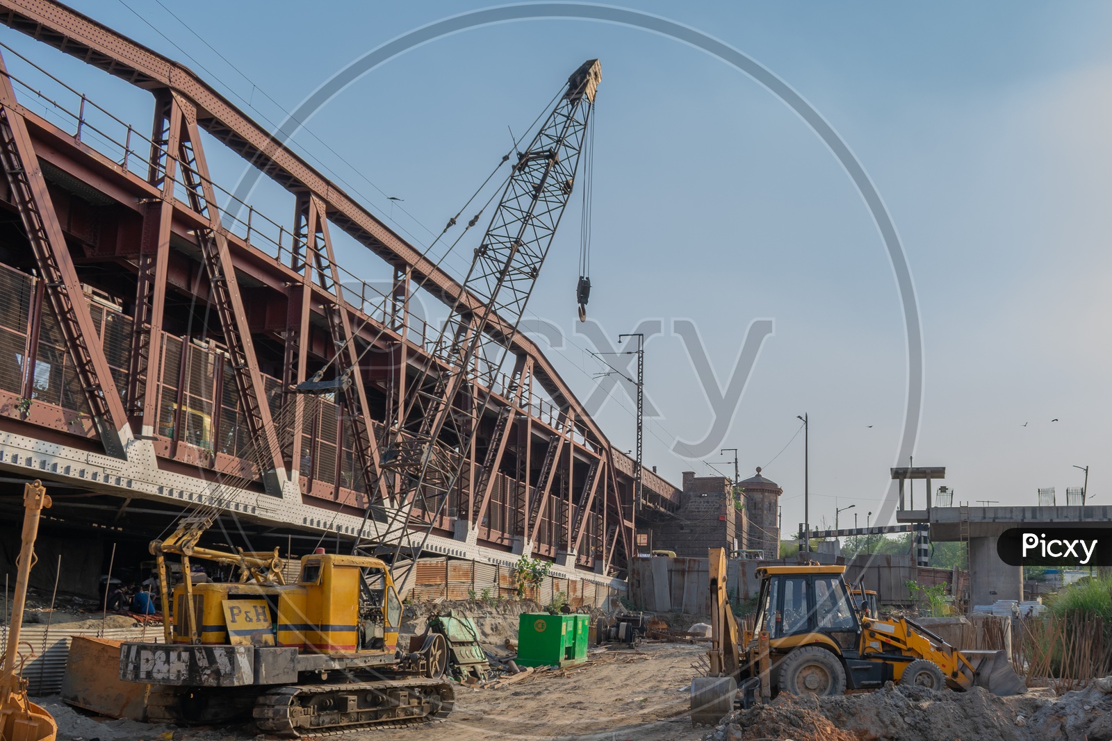 Crane machine and JCB during construction of rail bridge in Delhi