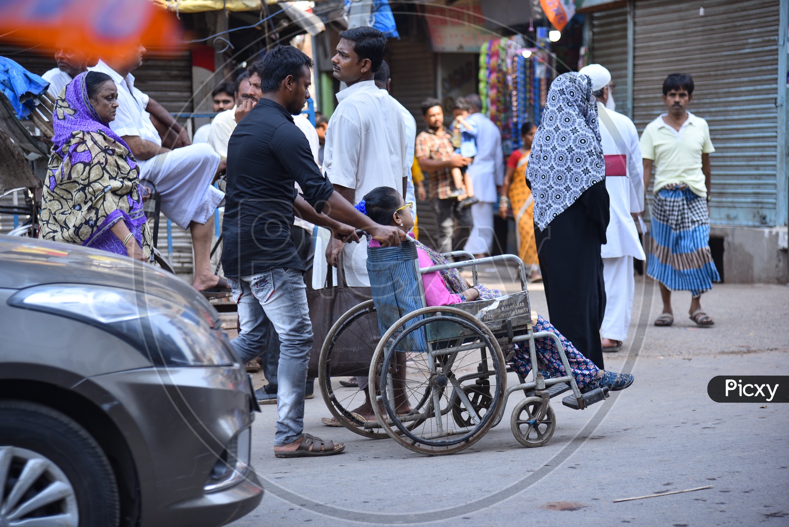 A Young Man Taking Physically Challenged woman In a Wheel Chair to a Polling Station