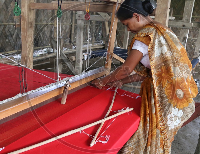 An Indian Woman Weaving The Hand loom  Saree Or Sari  in A Traditional Weaving Machine In Rural Village House