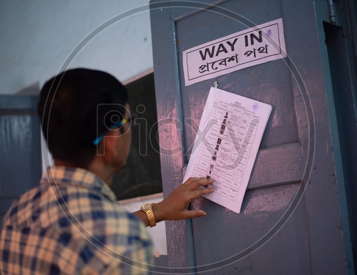 A Voter Checking His Vote Details From a Voter List Tagged At a Polling Booth