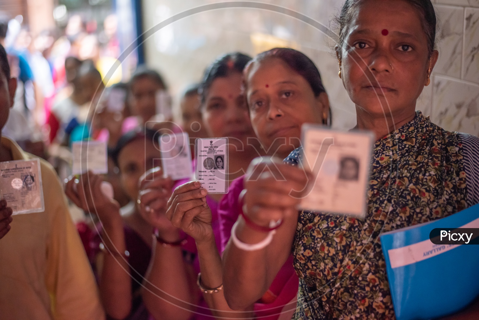Woman Voters Showing Their Voter Cards Being In Queue Lines At Polling Booths On Election Day
