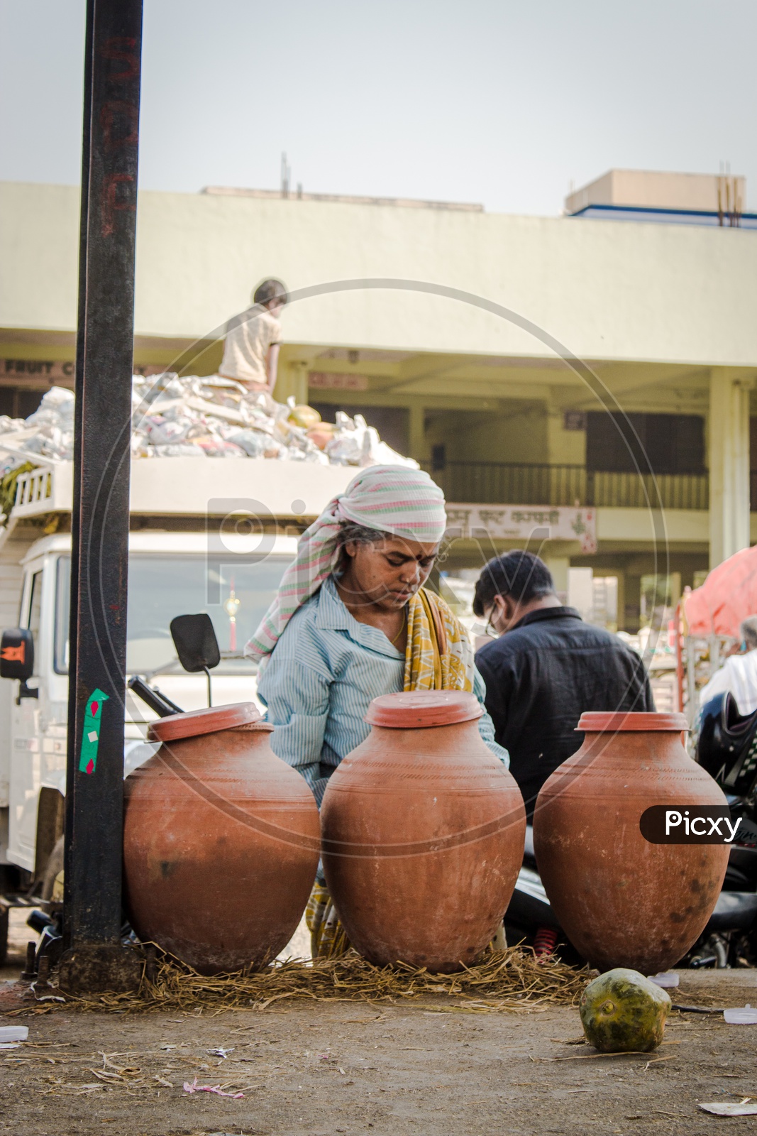 A woman drinking  water from clay pots