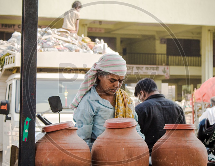 A woman drinking  water from clay pots