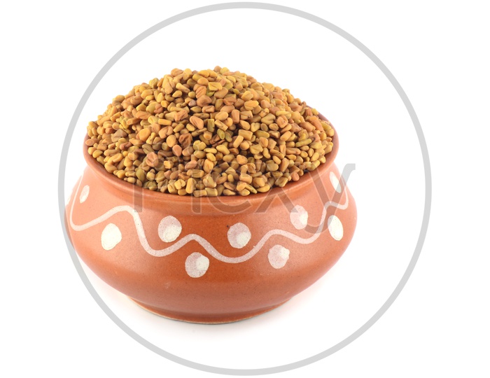 Fenugreek Seeds  in a Clay Pot On an Isolated White Background