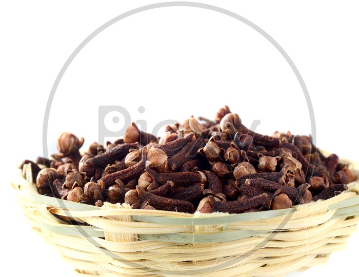 Cloves Or Indian Spice Cloves in a Wooden Weaved Basket  On An Isolated White Background
