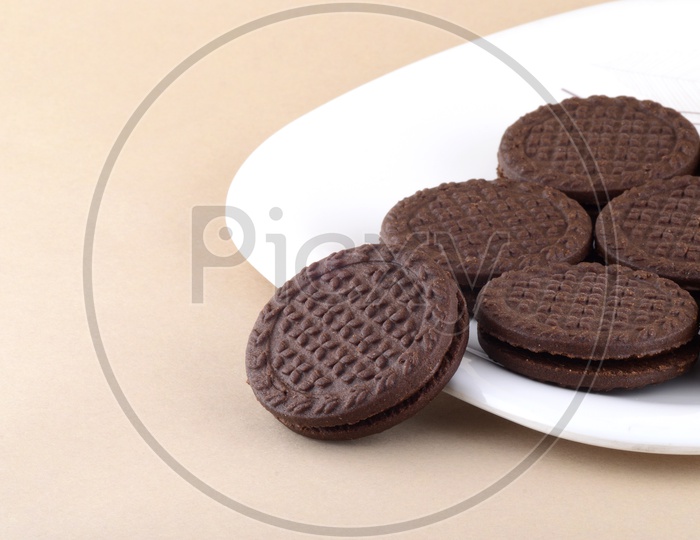 Brown chocolate sandwich biscuits with cream filling in plate