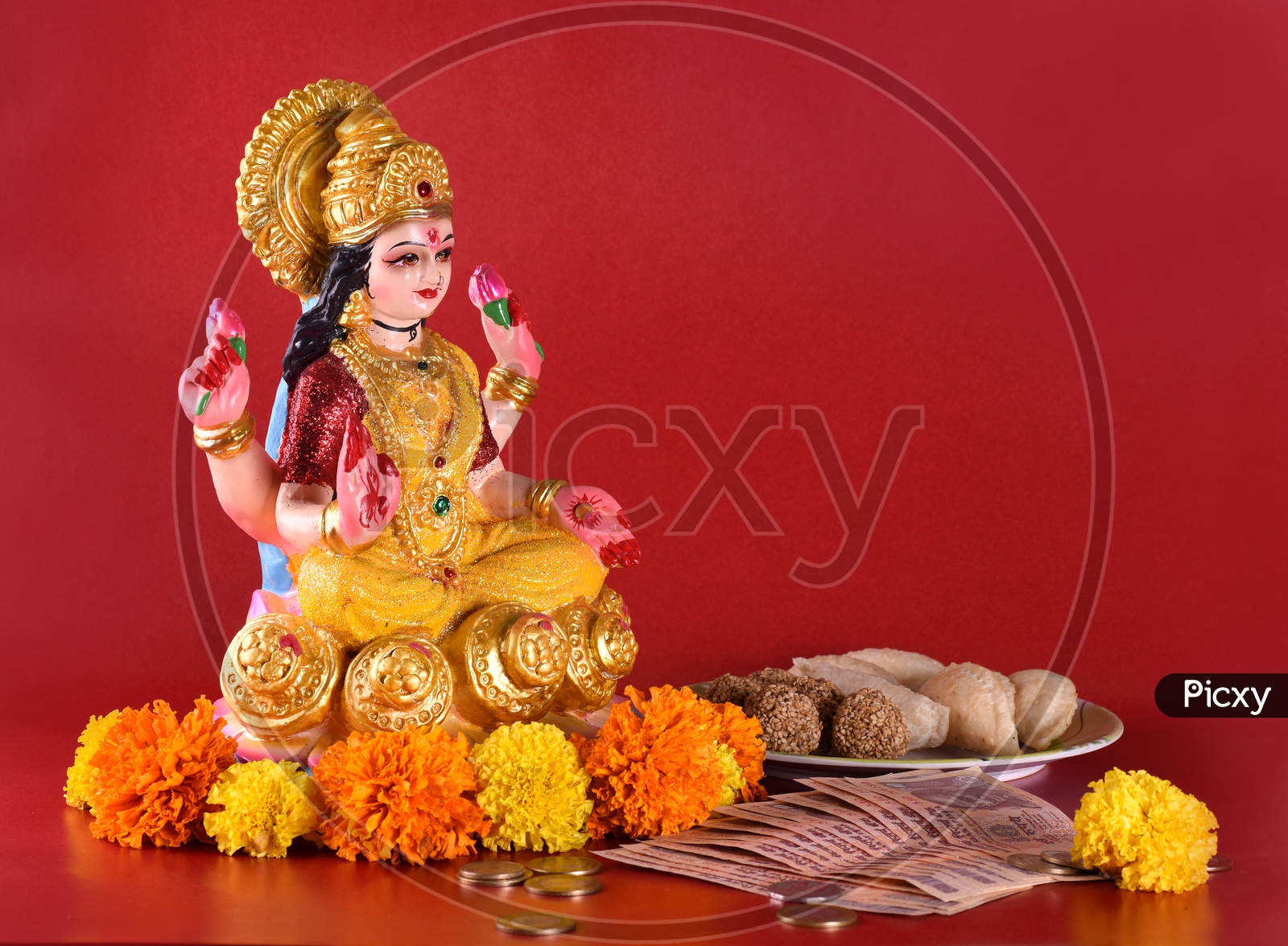 Indian Hindu Goddess Lakshmi Idols During Diwali Festival Worships  With Money And  Sweets  on an Isolated Background