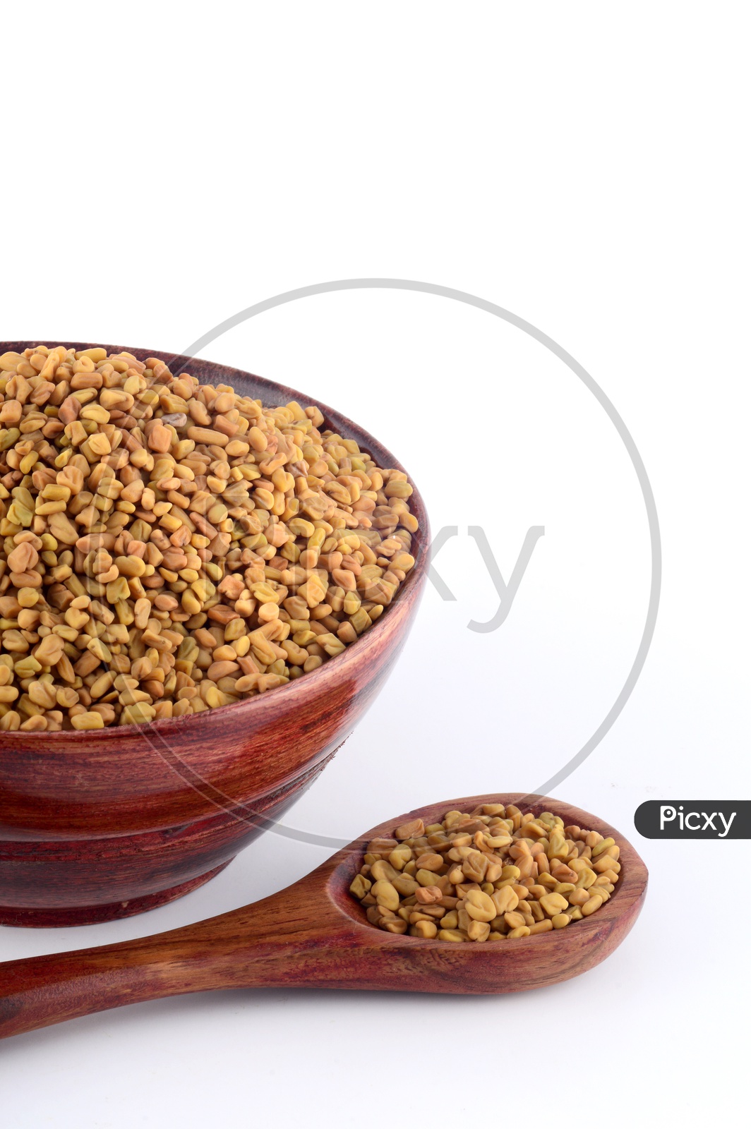 Fenugreek seeds in wooden bowl and spoon isolated on white background