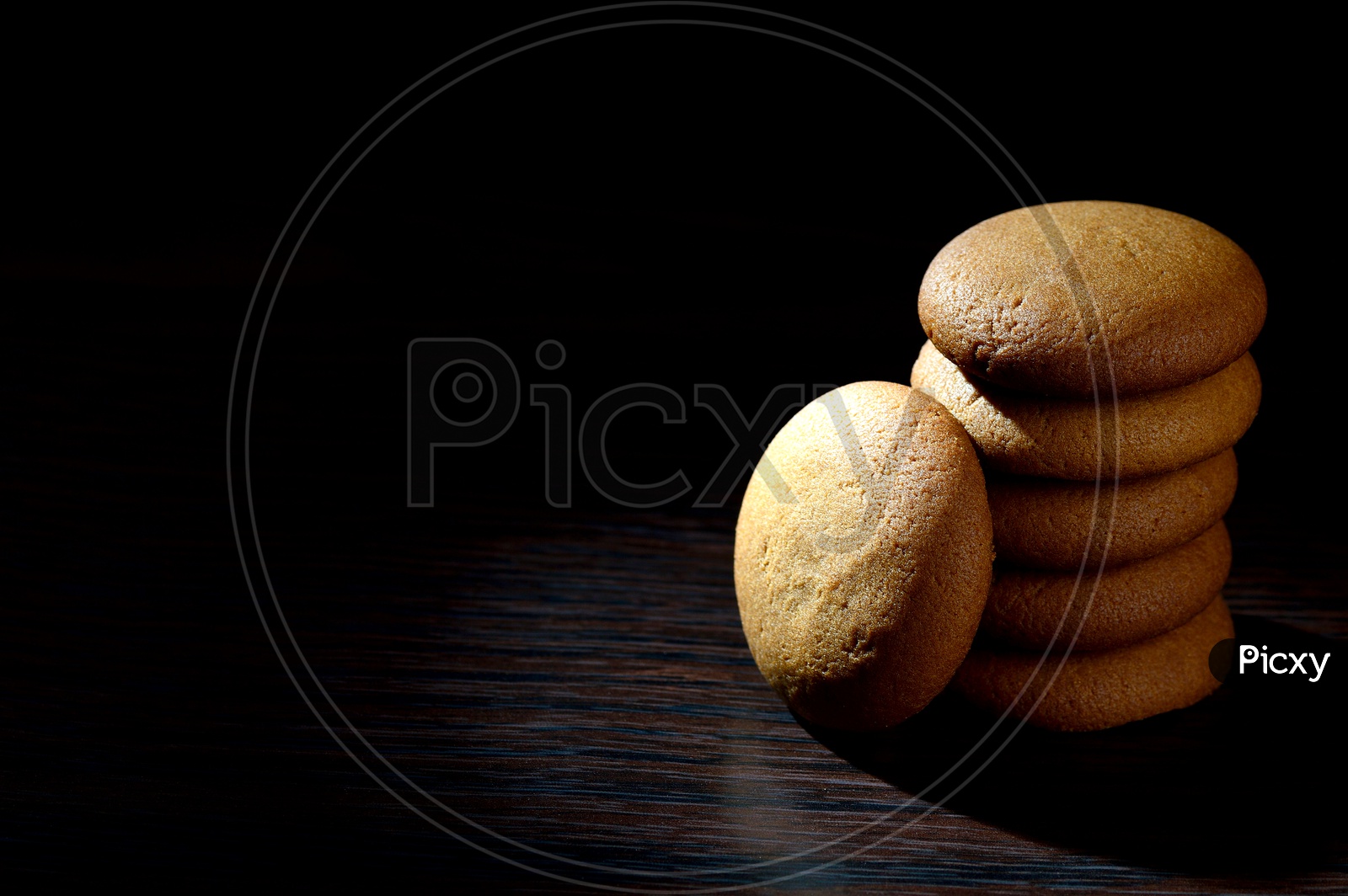 BISCUITS - Stack of delicious cream biscuits filled with chocolate cream on black background