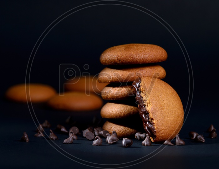 BISCUITS - Stack of delicious cream biscuits filled with chocolate cream on black background