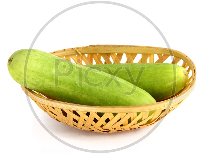 Fresh Green Cucumber Or Keera in a Wooden Weaved Basket on an Isolated White Background