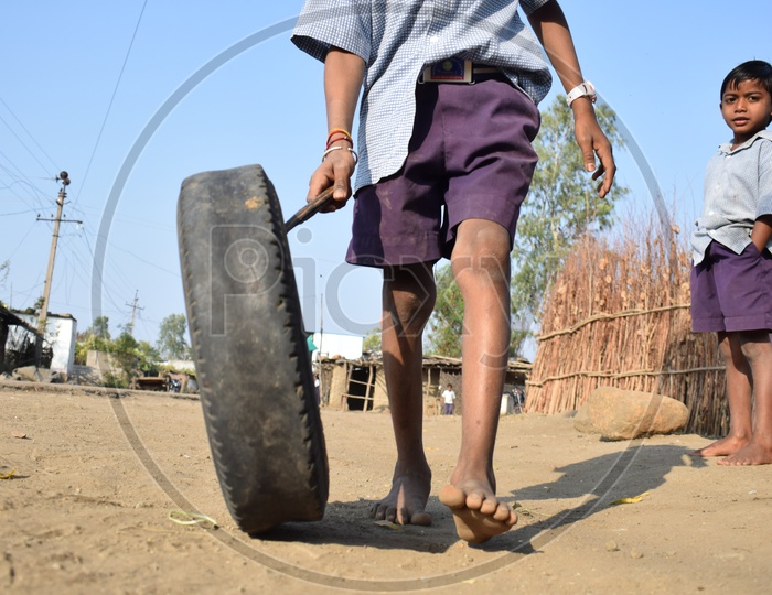 Tribal Village  Boy Playing By Rolling The Rubber Tire  in  Rural Tribal Village