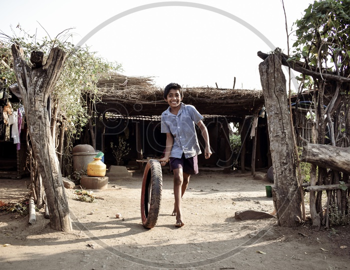 A Tribal Village Boy Playing  With a Rubber Tire