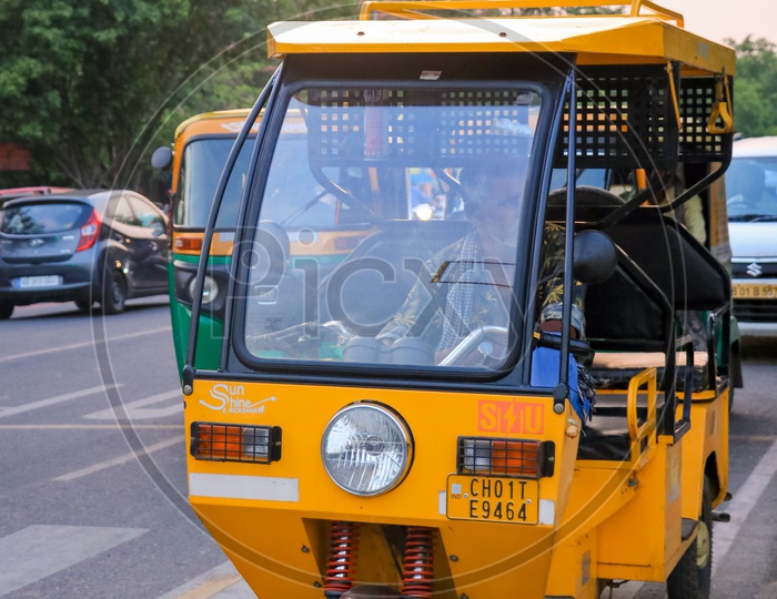 Yellow electric auto rickshaw on the road