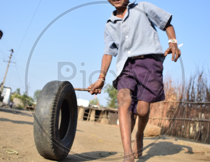 Tribal Village  Boy Playing By Rolling The Rubber Tire  in  Rural Tribal Village