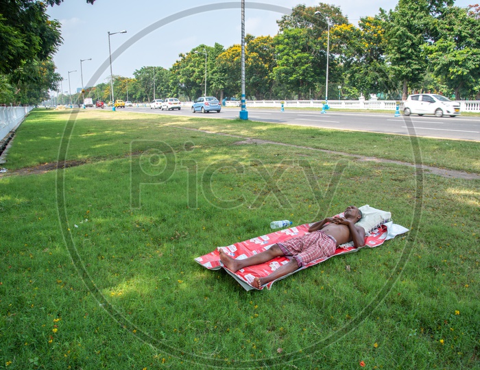 A homeless Man Sleeping On The Lawn Besides Res Road