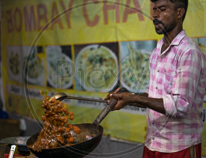 A person making a curry in the food stall