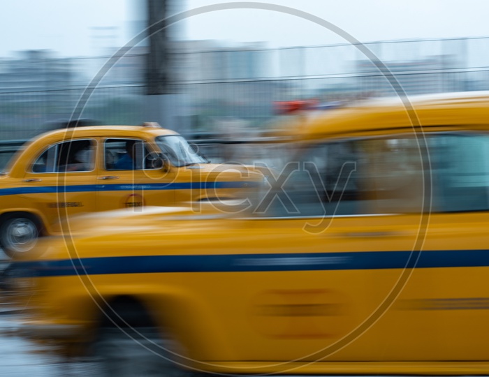 A Panning Shot Of  Yellow Color Cabs Or Taxis moving On Howrah Bridge