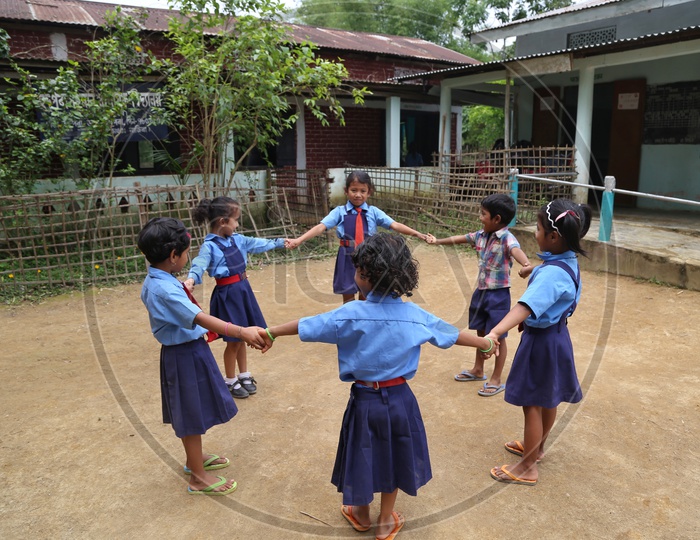 School children Or  School Students Wearing Uniforms And Playing Happily  in a Rural Village School Compound Or Premise