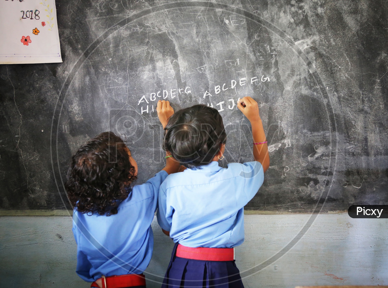 Girl Children Or Girl Students Writing On the Classroom Blackboard