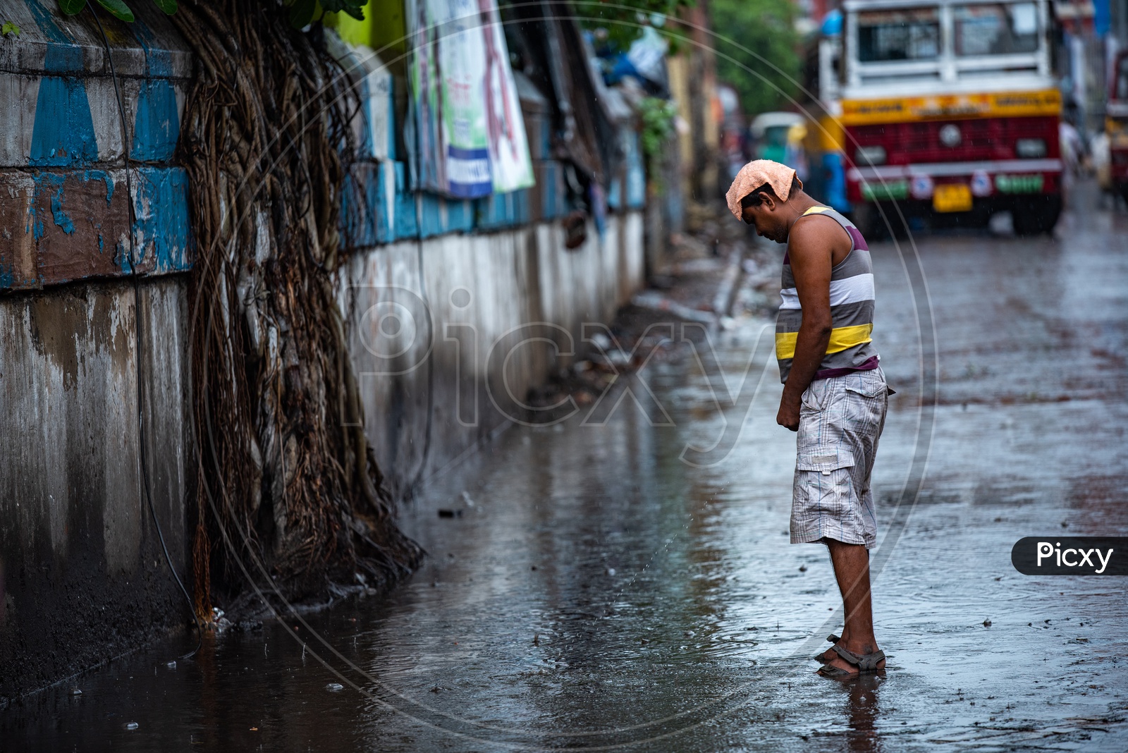 Image of A Man peeing/public urination on Over Flooded Roads in Kolkata Due  To Cyclone Fani-PG936550-Picxy