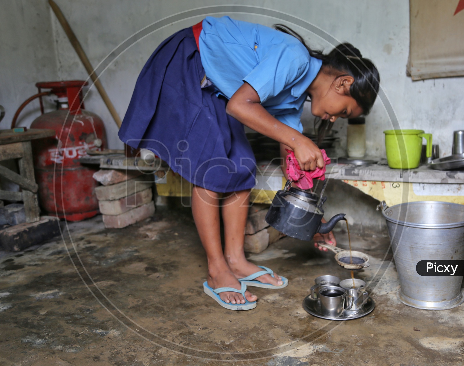 A School Girl Wearing Uniform And Making Tea in a Rural Village House