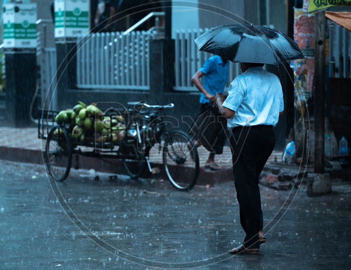 Pedestrians  Holding  umbrellas And Taking Cover from Heavy  Rain  Duer To Cyclone Fani  on  Howrah  Roads