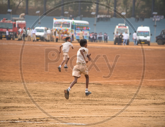 A School Boy in Uniform Running In a  Ground