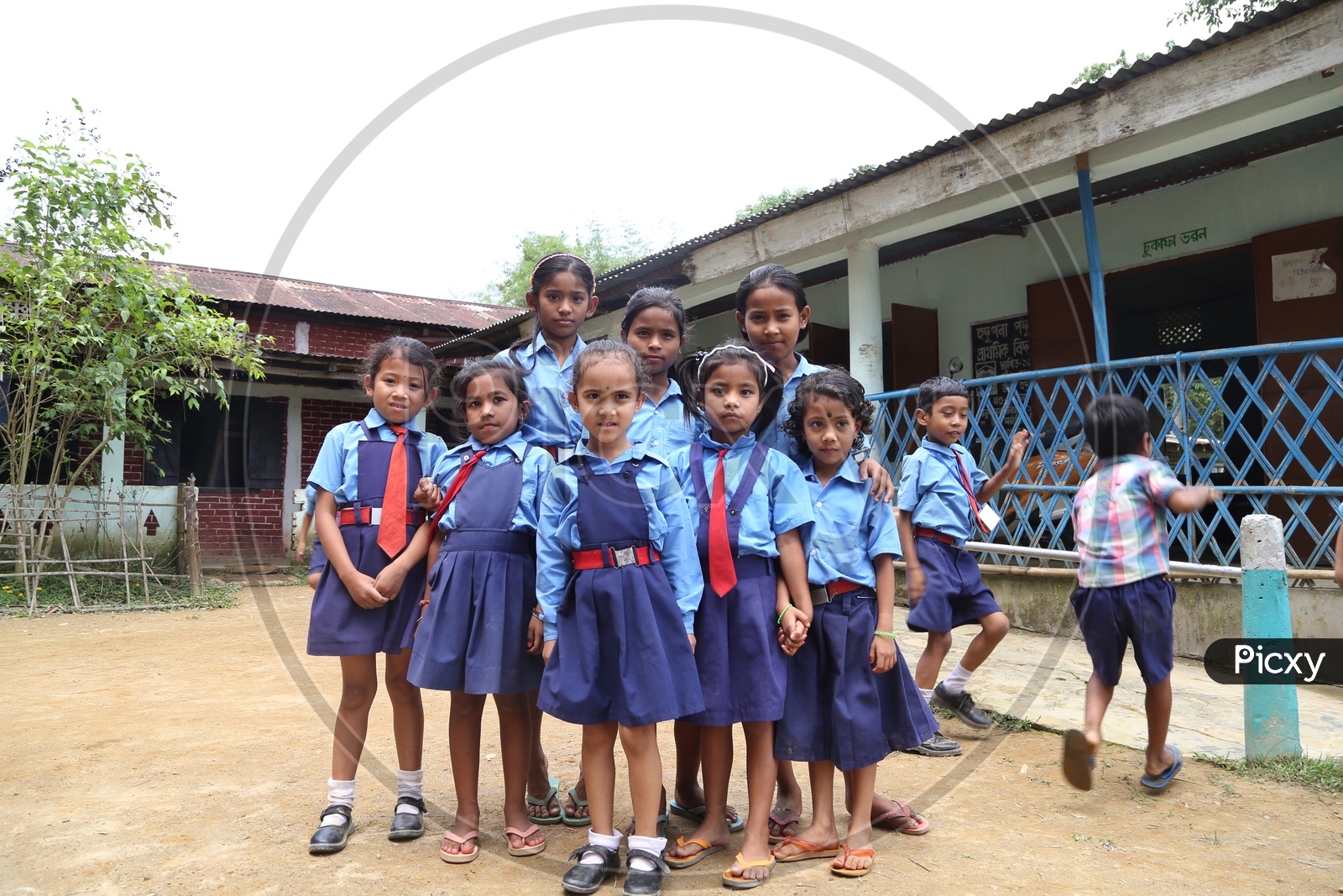 School Children Or School Students Wearing Uniforms  with Happily Smiling Faces   In a Rural Village School Premise Or Compound