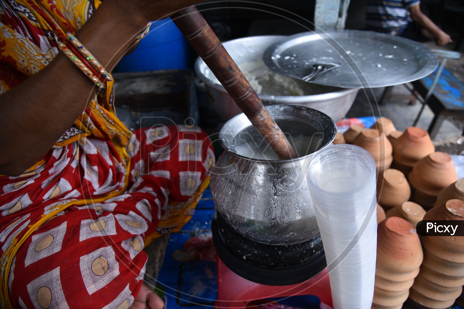 Churning Of Lassi  With a Wooden Churner  In a Vendor Stall