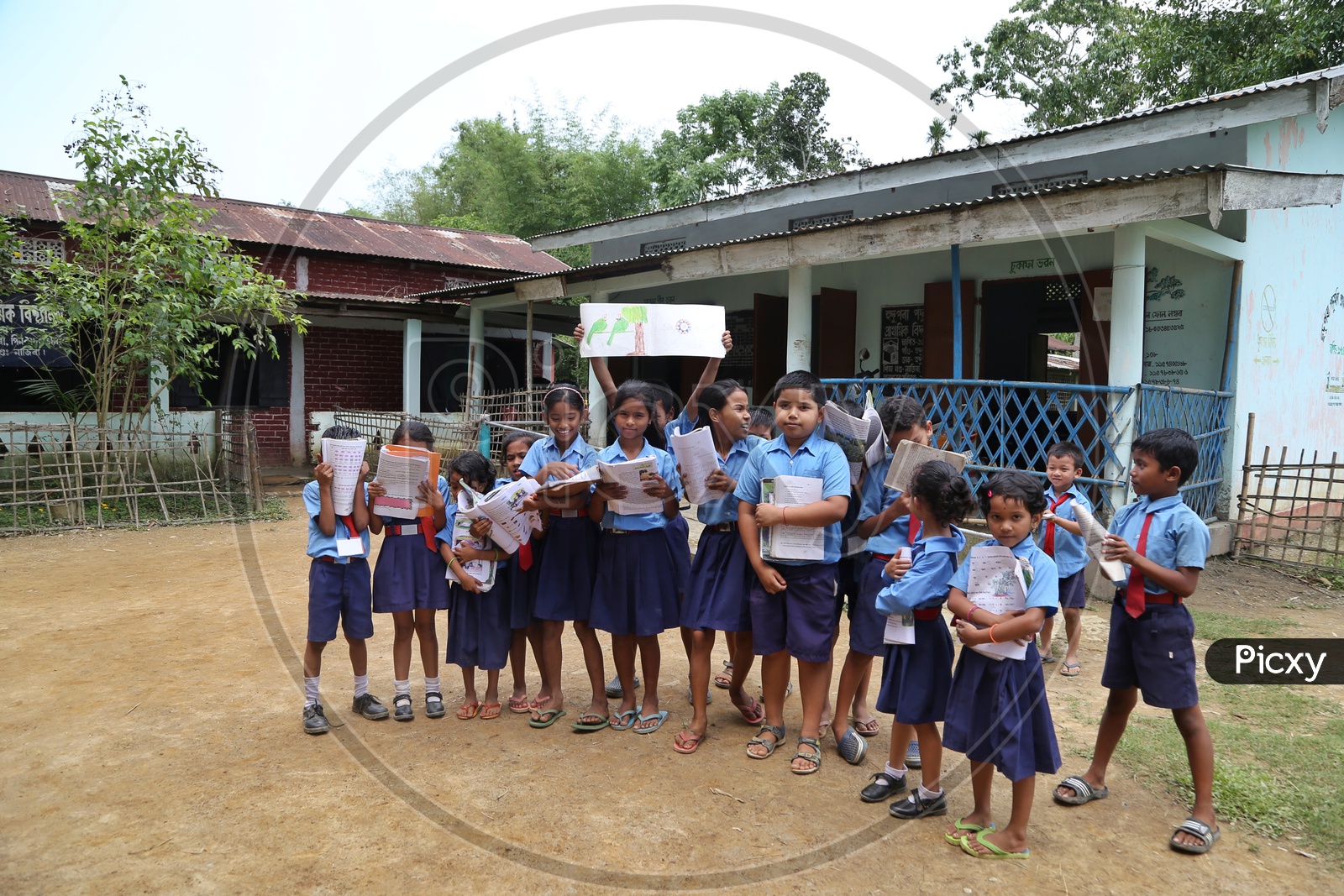 School Children Or School Students Wearing Uniforms  And holding Books  In Hands  In a Rural Village School Premise Or Compound