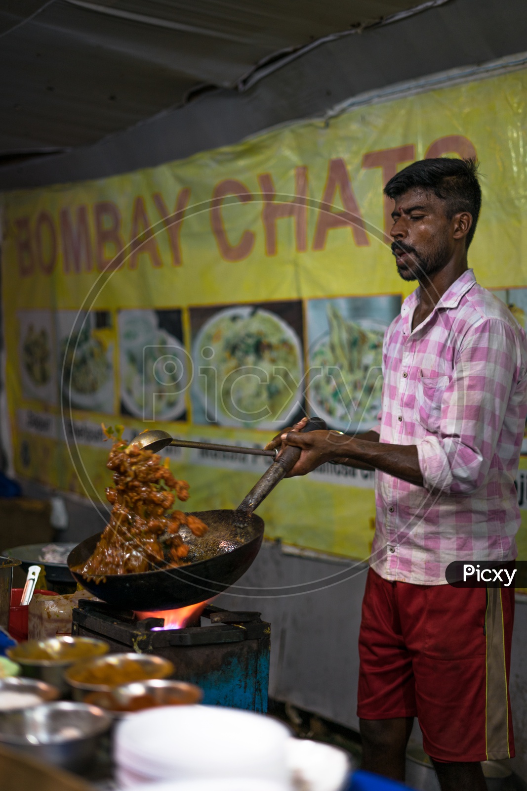 A person making a curry in the food stall