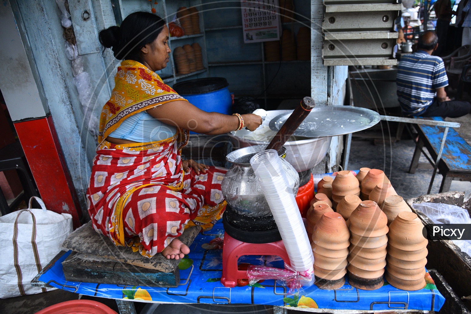 A Woman Vendor  Making Lassi  at a Vendor stall In Howrah
