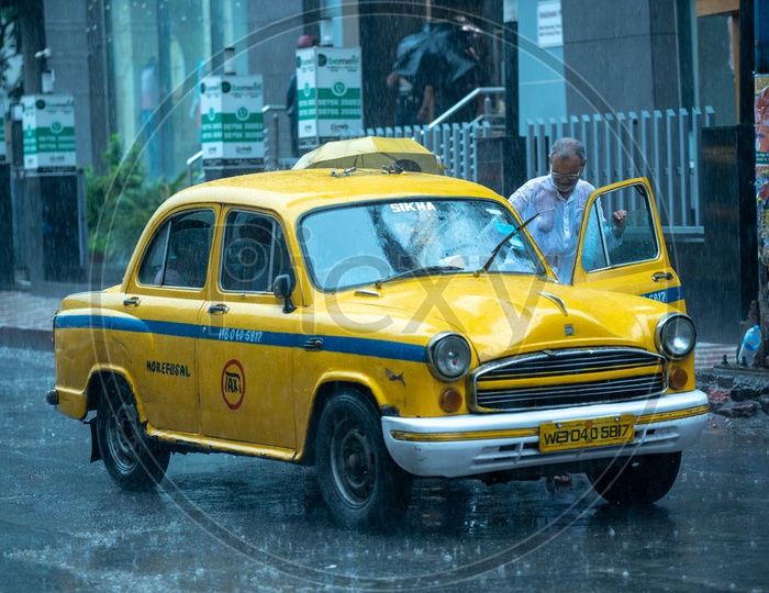 A Commuter Taking  a  Yellow Cabs Or taxis   in Heavy Rain Due To Cyclone Fani