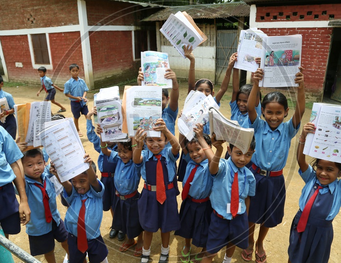 School children Or  School Students Wearing Uniforms And Holding Books In Hand   in a Rural Village School Compound Or Premise