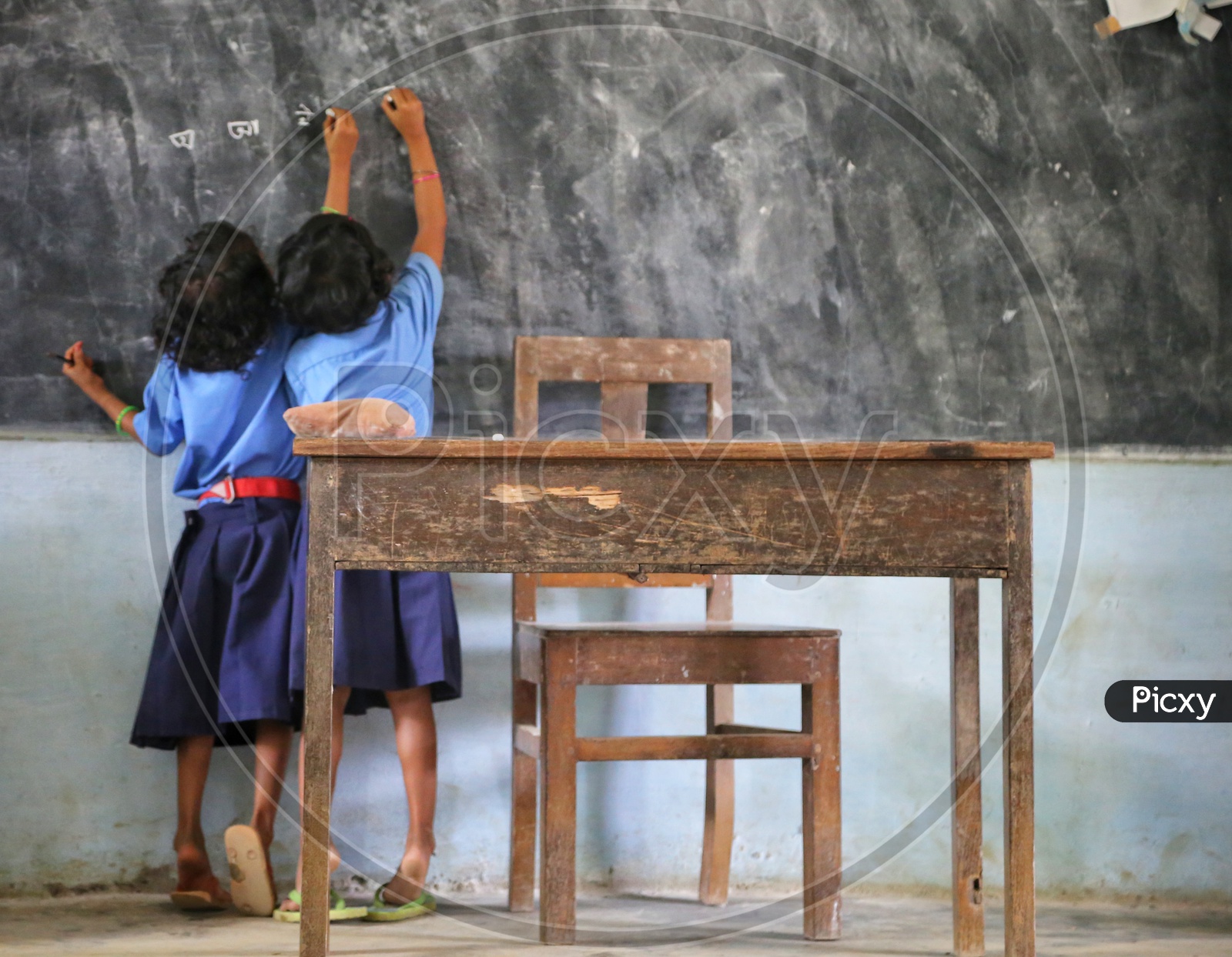 Girl Children Or Girl Students Writing On the Classroom Blackboard