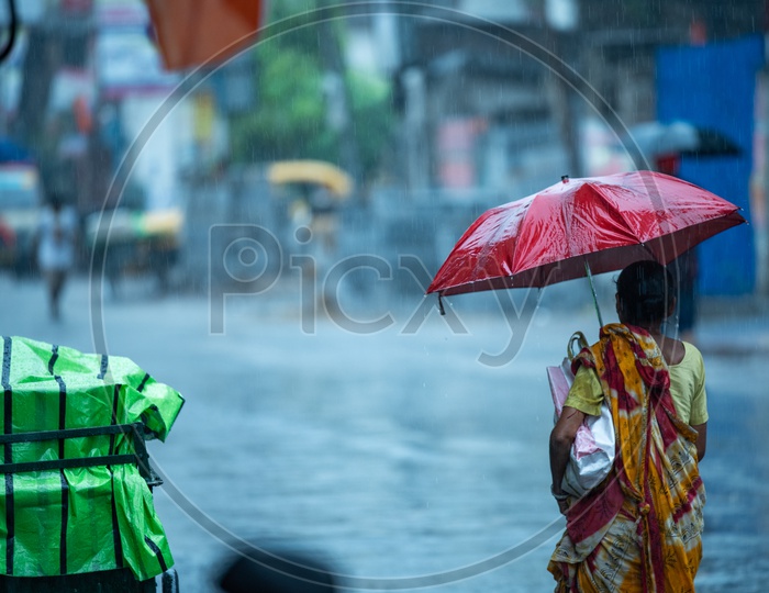 A Woman  Pedestrians  Holding  umbrellas And Taking Cover from Heavy  Rain  Duer To Cyclone Fani  on  Howrah  Roads