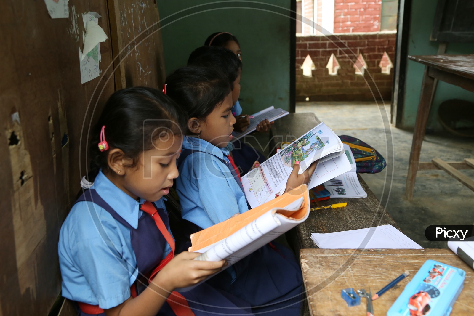 School Children  or School Students In a Classroom Wearing  School Uniforms With Books  in a Rural Village School